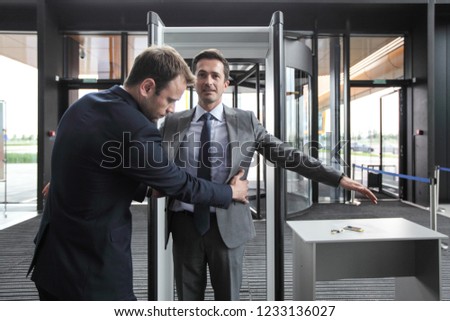 Security man check businessman at entrance in office building or airport Royalty-Free Stock Photo #1233136027