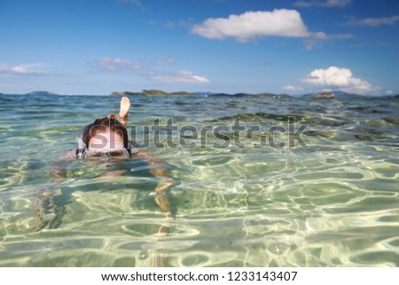 A woman snorkeling in a tropical sea near sandy beach with beautiful color and clear water on Caribbean