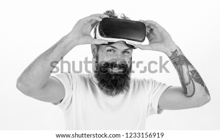 Man with beard and mustache holds VR glasses, white background. VR technology concept. Guy with VR glasses or head mounted display. Hipster on smiling face use modern technologies for entertainment.