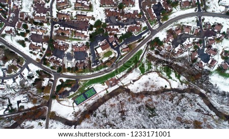 Birds eye view of a winding street on a cold, snowy day.