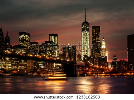 Brooklyn Bridge, East River and Manhattan at night with lights and reflections. New York City