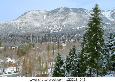 Picture taken in Germany in the resort town called Garmisch - Partenkirchen. The picture shows a winter landscape with mountains overgrown with forest and valley in which the town is located.