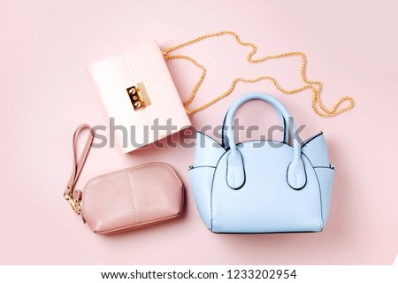 Fashion handbags on pale pink background. Flat lay, top view. Spring/summer fashion concept in pastel colored Royalty-Free Stock Photo #1233202954