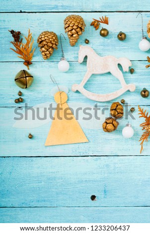 handmade paper angel and other Christmas ornaments on blue wooden table, soft light