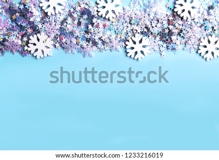 Christmas and New Year decorative background with small glitter starsand white snowflakes. Colorful tinsel. Festive confetti.