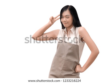 cute asian girl make two finger symbol like figthing on her chin with apron service suite on white isolated (include clipping path) 