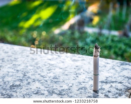 A Cigarette with Smoke and Blurred Background. Quit Smoking Sign. No Smoke. Stop Smoke. Cancer