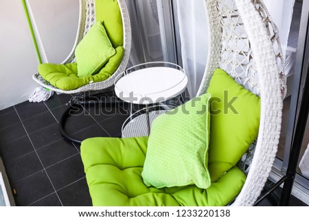modern decorative balcony style. apartment exterior style with furniture and colorful object. Beautiful terrace or balcony with small table and two green chairs and black floor