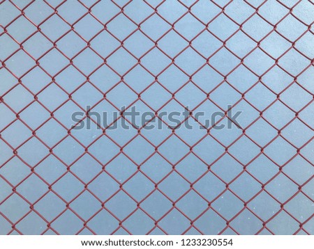 red steel mesh on cement wall background.