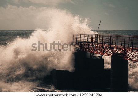 Huge ocean waves breaking against the pier