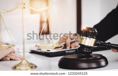 discussing contract papers with brass scale and  gravel on wooden desk in office. Judgment, Litigation, Legal Counsel service concept.