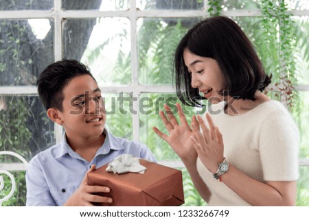 Boy giving a gift box to girl for birthday, christmas and new year present
