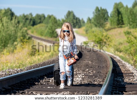 Traveler little girl on railway in summer sunset