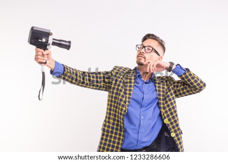 Technologies, photographing and people concept - portrait of funny young brunette man taking selfie with camera on white background