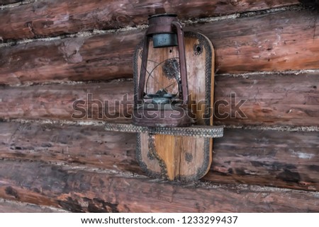 kerosene lamp on a wooden shelf in a wooden log hut