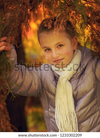 Happy girl laughing and playing in autumn leaves