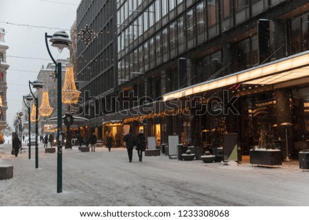Central streets of Helsinki during the new year holidays decorated with garlands and lights during the snowfall