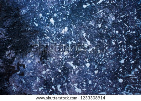 Splashes of white paint on a dark blue background (as an abstract grunge background)