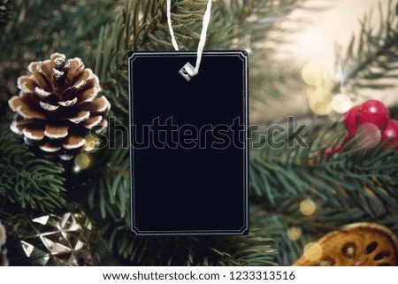 mockup tag paper card with pine cones christmas decoration on wood table background.