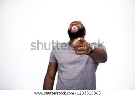 Sneer, a finger, mocks someone and laughing man. Hand in focus. In the blur of an African American guy. Emotion, moral abuse, social influence, public opinion, elected to be exposed for a fool Royalty-Free Stock Photo #1233315865