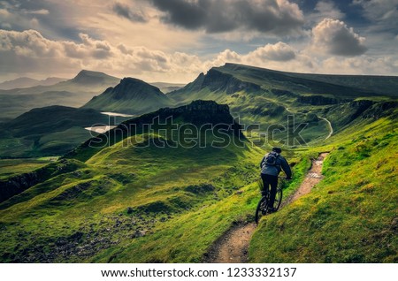 Mountain biker riding through rough mountain landscape of Quiraing, Isle of Skye, Scotland, UK Royalty-Free Stock Photo #1233332137