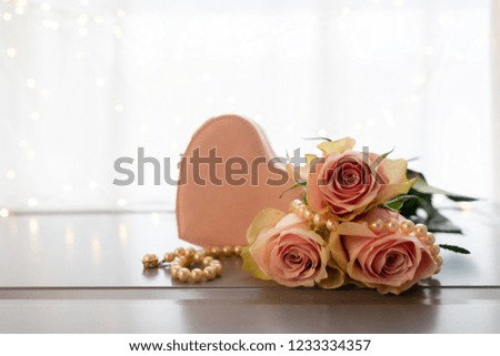 Rose fresh flowers bouquet on gray table by the window with heart