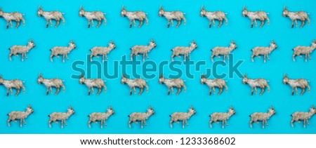 Creative and minimal pattern made of goats. Blue background. Flat lay top view.