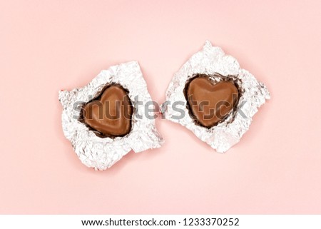 Chocolate hearts in foil on pink background Royalty-Free Stock Photo #1233370252