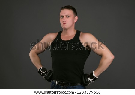 Portrait of fighter or boxer man that is holding his hands on his belt isolated on gray background. Concept photo.
