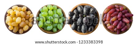 Grapes in a wooden bowl isolated on white background. Blue, yellow, red and green grapes on white background. Vegetarian or healthy eating. Top view. Set of different grape varieties
