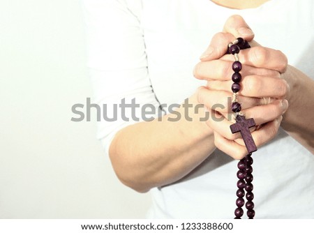 Woman holding a cross in her hands on white background symbolizing love of god stock photo