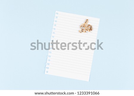 one blank sheet with musical notes icon
 on blue background top view, spiral notepad blank empty sheet. flat lay