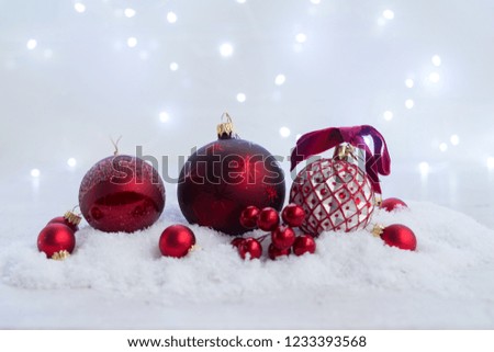 Christmas scene with snow - red balls decorations with lights in background