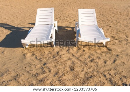 Two sunlongers on the sand beach in summer. Royalty-Free Stock Photo #1233393706