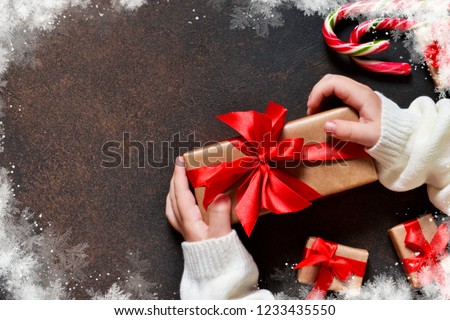 New Year card. A box with gifts in the hands of the child.