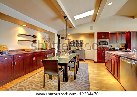 Luxury modern dining room with mahogany kitchen and glass table.