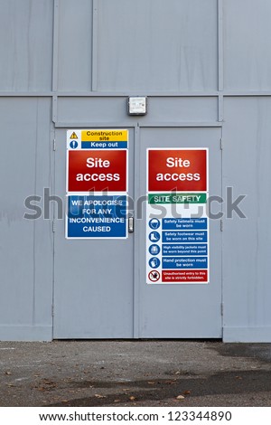 Construction site access door with warning signs
