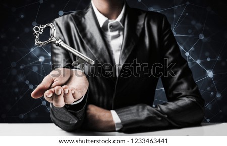 Cropped image of businessman in suit keeping big key in hand with network connections on background.