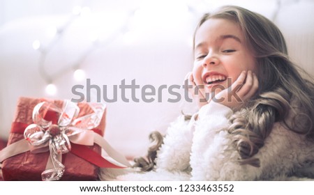 Christmas and holiday concept-cute little girl with a gift in a red box