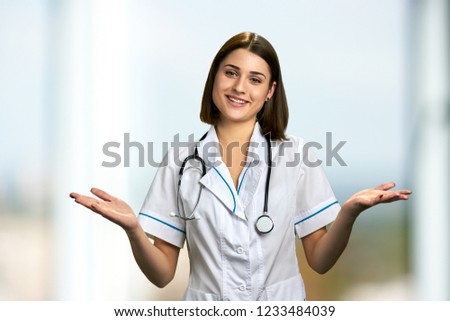 Smiling woman doctor with outstretched hands. Portrait of happy doctor with empty hands palm.