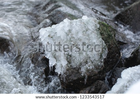 baltic sea close up:   huge brown frozen rock from wave breaker with ice and icicles, aerial photo in water, outdoors in Gdańsk, Europe, Poland