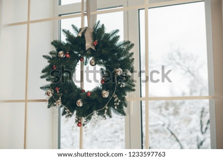 Christmas wreath on the window. Festive decor in bright colors.