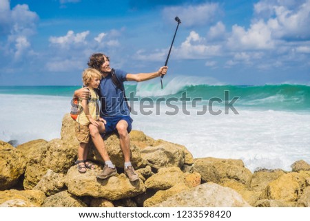 Dad and son travelers on amazing Melasti Beach with turquoise water, Bali Island Indonesia. Traveling with kids concept