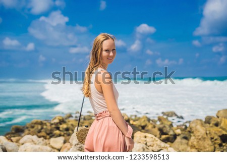 Young woman traveler on amazing Melasti Beach with turquoise water, Bali Island Indonesia