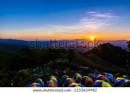 tent in the sunset overlooking mountains .