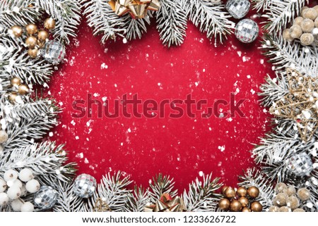 Merry Christmas and Happy Holidays greeting card, frame, banner. New Year. Noel. Christmas white and silver ornaments on red background top view. Winter holiday xmas theme. Flat lay.