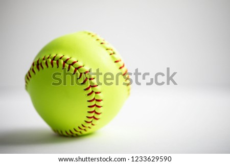 A yellow softball on a white background shot with a macro lens