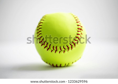 A yellow softball on a white background shot with a macro lens