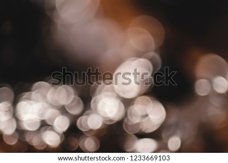 Soft focus bright white and gold defocused bokeh against a deep dark background