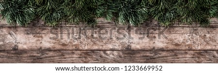 Creative layout frame made of Christmas fir branches, pine cones on wooden background. Xmas and New Year theme. Flat lay, top view, wide composition